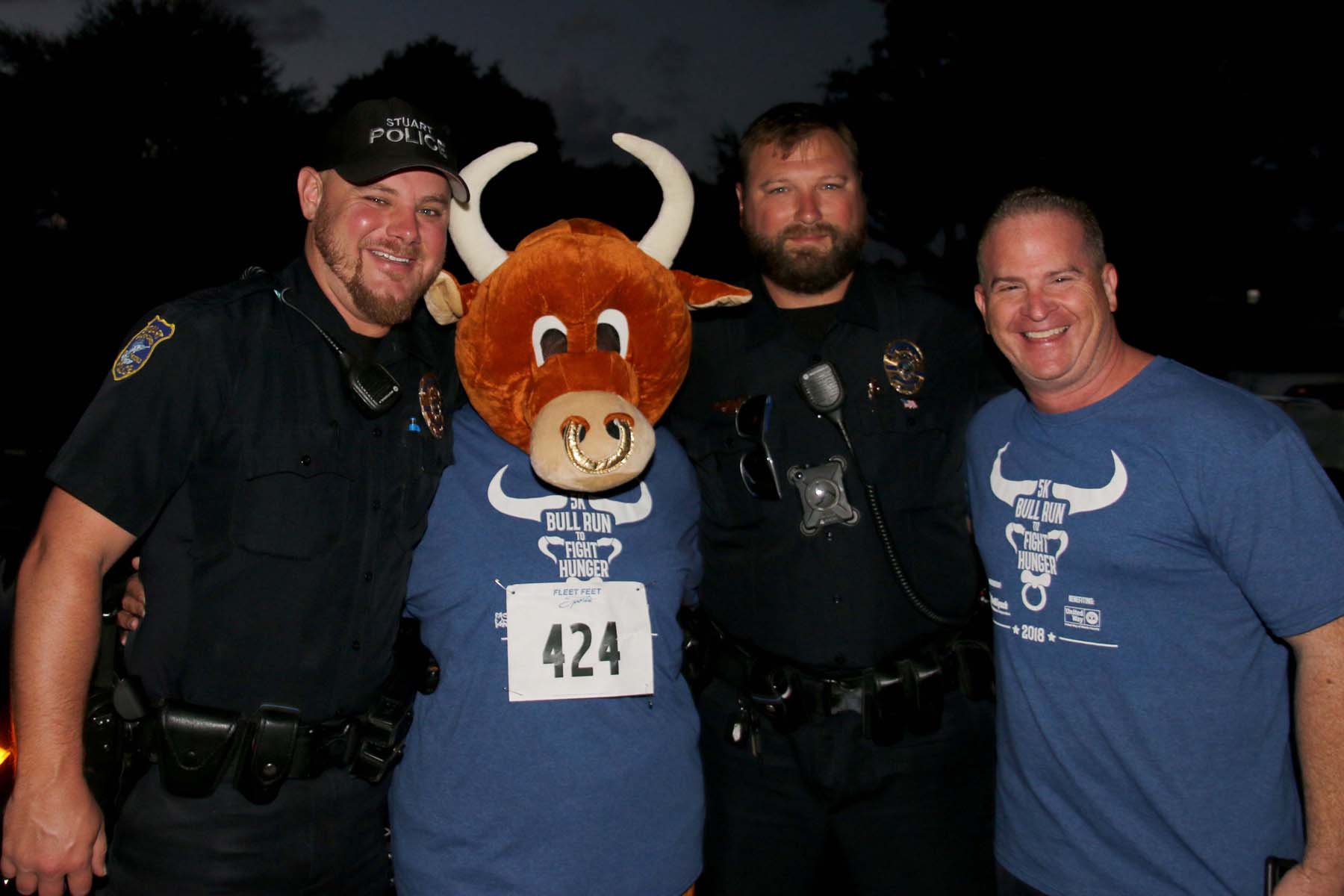 Runner and police next to bull mascot